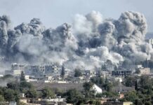 Massive smoke plumes rise over a city after explosions