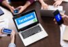 Laptop with Facebook on screen surrounded by smartphones