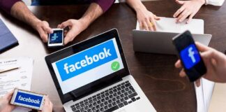 Laptop with Facebook on screen surrounded by smartphones