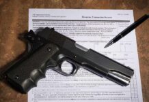 Handgun on a firearms transaction form with a pen