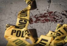 Crime scene tape near blood on pavement