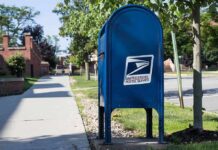 Blue USPS mailbox on a suburban sidewalk