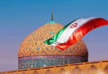Iranian flag waves before an ornate mosque dome at sunset