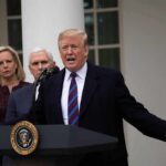 Donald Trump speaks at a podium with Mike Pence and Kevin McCarthy nearby