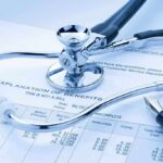 A stethoscope resting on a medical billing statement