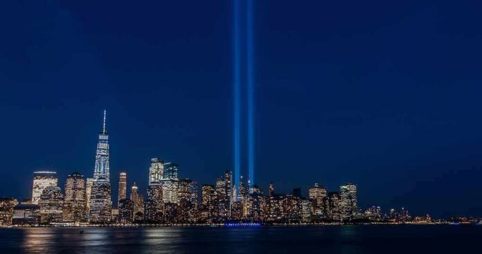 City skyline at night with twin blue light beams rising into the sky
