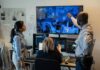 Security team monitors multiple surveillance screens in control room