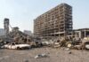 Burned-out cars amid a gutted high-rise building
