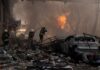Firefighters tackle blaze amid rubble and a burned car