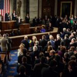 Legislators give a standing ovation in a grand chamber