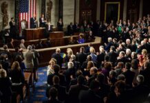 Legislators give a standing ovation in a grand chamber