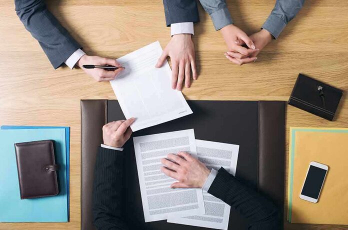 business meeting with hands reviewing and signing documents