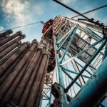 Oil drilling rig structure with stacked pipes viewed from below