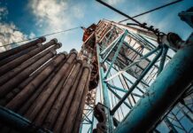 Oil drilling rig structure with stacked pipes viewed from below