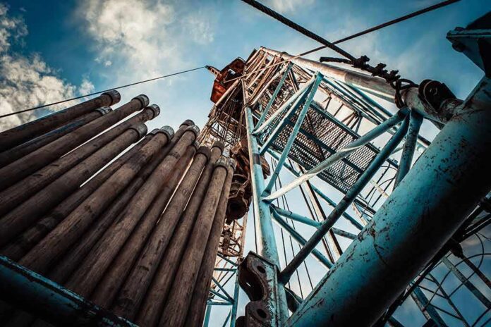 shutterstock_422487748 Oil drilling rig structure with stacked pipes viewed from below