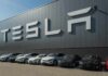 Cybercab Delay Sparks Big Money Play Tesla cars parked outside a large Tesla building