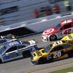 Stock cars racing side by side on a banked track
