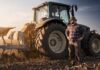 Harvest Rescue: $8B Diesel Bailout Farmer standing beside a tractor in a plowed field