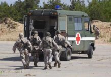 Soldiers running towards a medical vehicle during a military operation