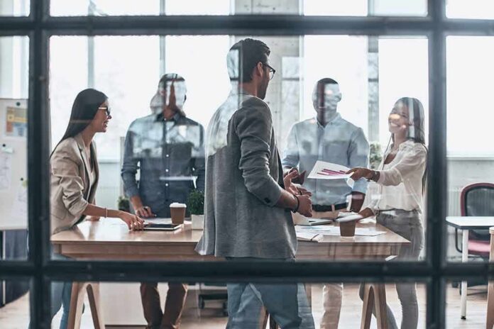 Team meeting in a modern office behind glass windows