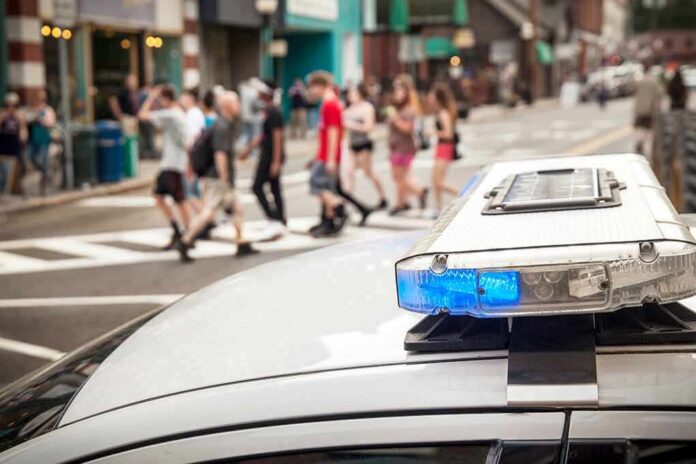 police car roof light bar with blue lights near a busy crosswalk