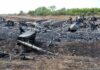 Airplane crash debris scattered across a burned field