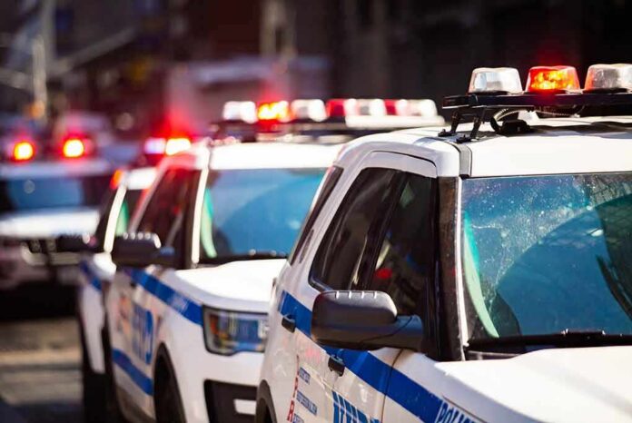 shutterstock_1375359047 police cars with flashing lights on a city street