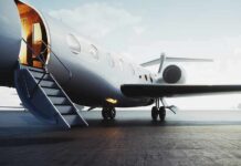 Private jet on tarmac with open door and boarding stairs