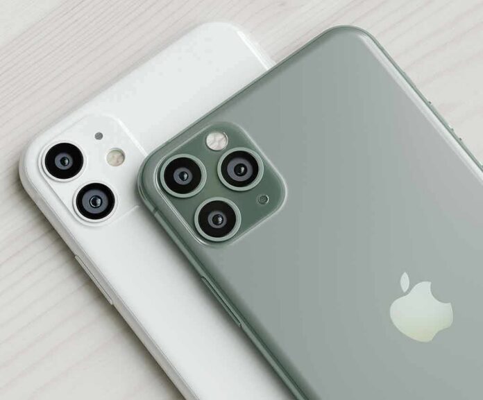 smartphones with dual and triple rear cameras on a light wood surface