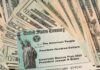 U.S. Treasury check on top of scattered dollar bills
