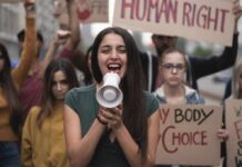Young woman leading a protest with a megaphone