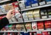Banned Stock Seized – Death Link Eludes Hand selecting a pack of cigarettes from a store shelf