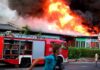 Firetruck at a building engulfed in flames