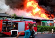 Three-Mile Lockdown Over Mystery Fumes Firetruck at a building engulfed in flames
