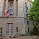 Stone government building with American flag at entrance