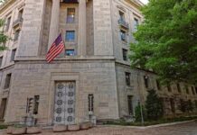Stone government building with American flag at entrance