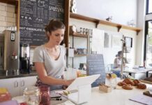 Barista using a tablet register at a cafe counter
