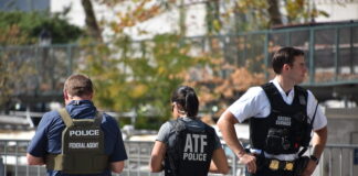 Authorities standing together outdoors wearing law enforcement gear