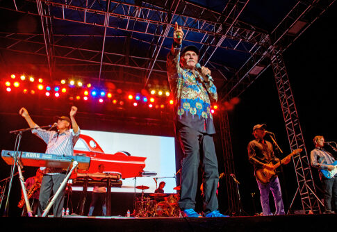 A band performing under colorful stage lights.