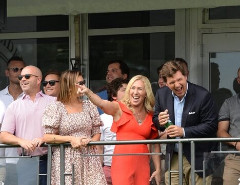 Group of people standing and smiling at golf event.