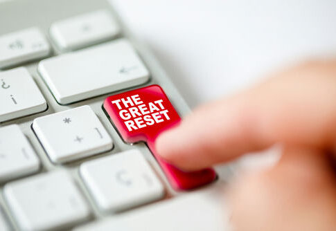 Finger pressing The Great Reset key on keyboard.