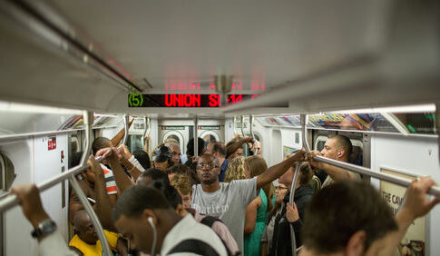Crowded subway train with standing passengers sign reads Union St