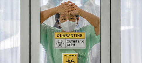 Person wearing mask behind quarantine glass, outbreak alert sign.