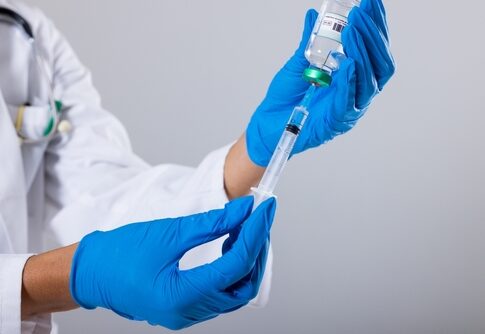 A healthcare professional preparing a syringe with a vaccine