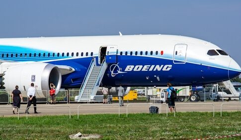 Boeing 787 airplane at an airport with passengers boarding