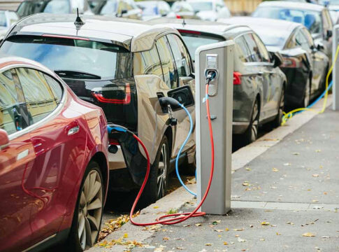 Electric cars charging at street charging stations.