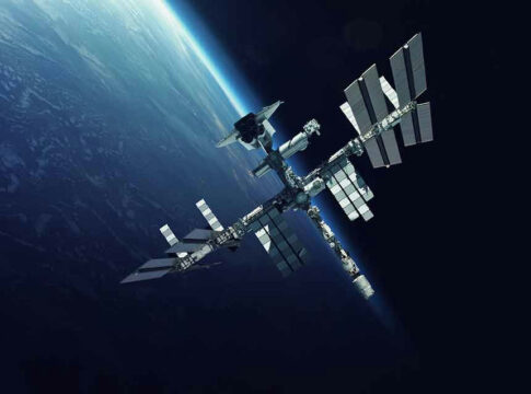 Space station orbiting Earth surrounded by dark sky.