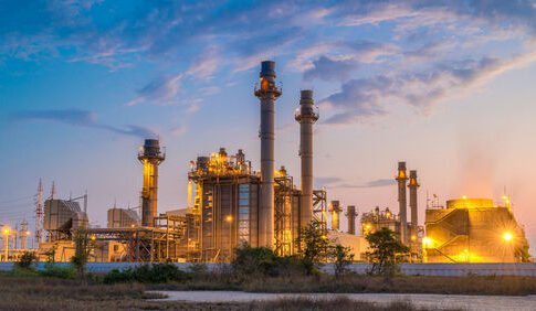 Industrial plant with smokestacks at dusk.